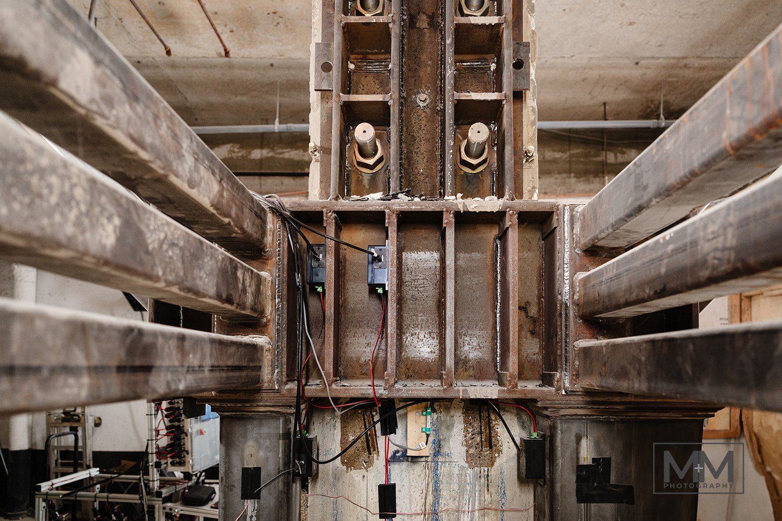 Looking up at the steel bracket assembly wrapped around the column, with diagonal braces and stiffened plates