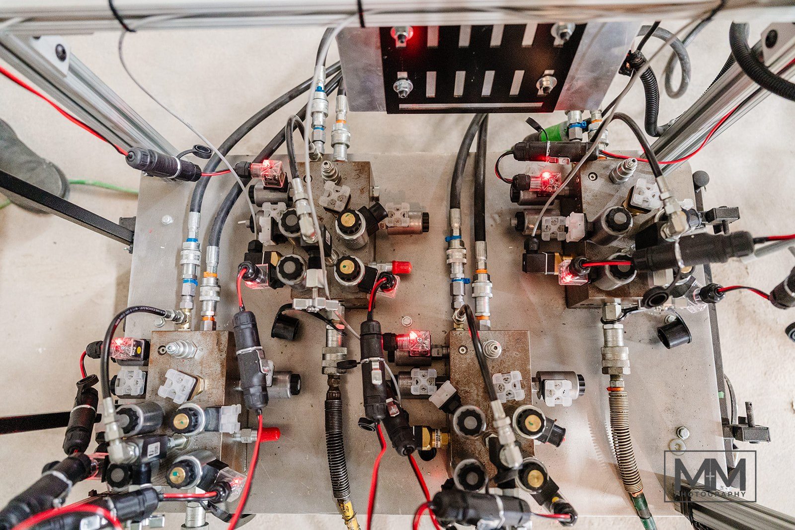 Hydraulic valve manifolds with solenoid valves and hoses on a mounting panel