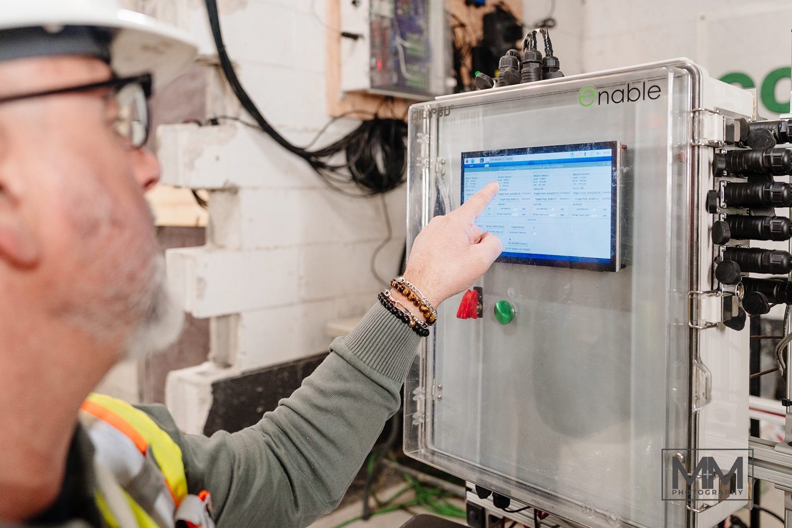 An engineer using the touchscreen on the Enable hydraulic control cabinet